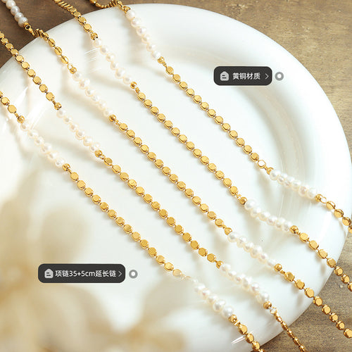 Multiple gold disc pearl necklaces on white dish with material length labels