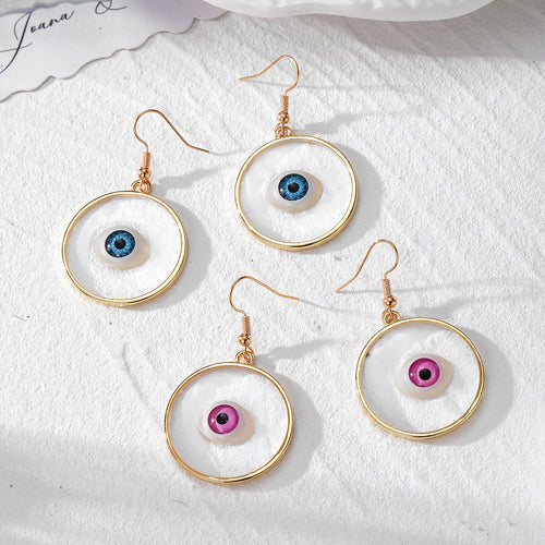 Four gold ring resin eyeball earrings in blue and pink on white fabric