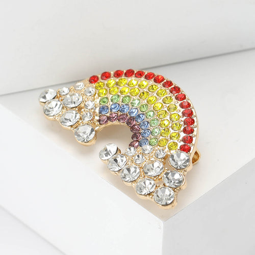 Angled display of the rainbow brooch on a white surface