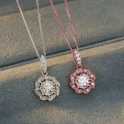 White gold and rose gold flower CZ pendants on gray steps