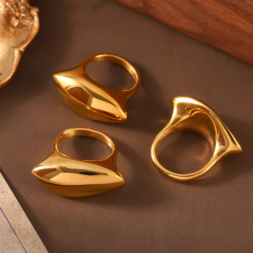 Three gold marquise oval rings on brown surface various angles