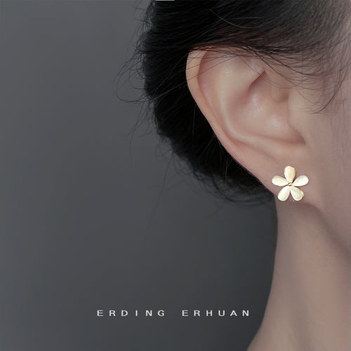 Cream flower stud worn on ear side profile close-up