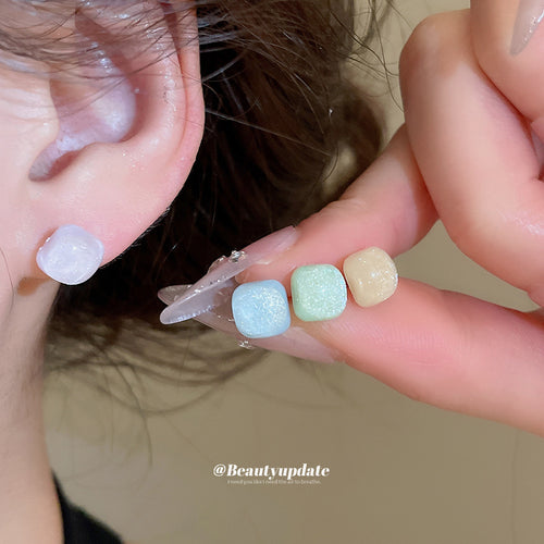 Two six-piece sets of softly colored square resin studs in a close product view.