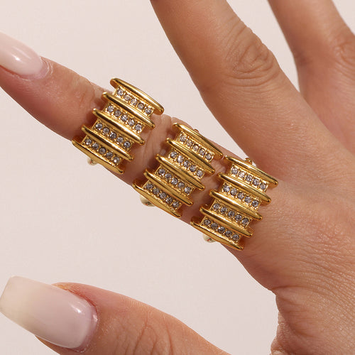 Close-up three gold bar rings stacked on two fingers