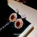 Gold Tone Red Oval Crystal Drop Earrings with Clear Halos view 2