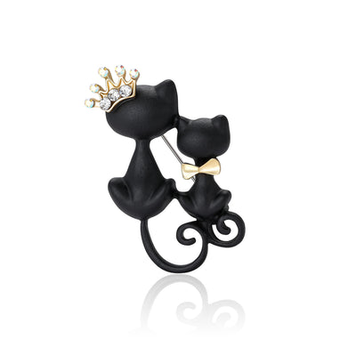 Front view of two black cat silhouettes with curled tails and small crown details