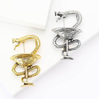 A coiled snake wrapped around a stemmed cocktail glass shown on a white background.