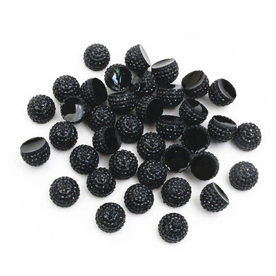 Overview of textured black half-round resin cabochons with flat backs on a light background