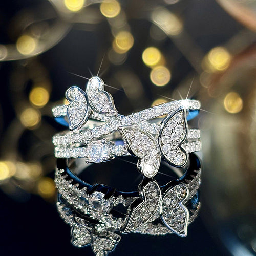 Silver-tone multi-band butterfly ring reflected on black