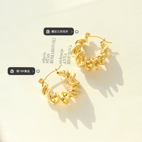 Pair of gold twisted rope hoops on book with plating labels