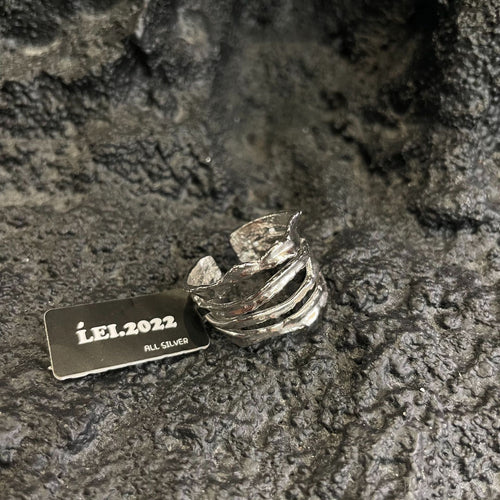 Silver four-layer open stack ring product shot with LEI.2022 tag on rock
