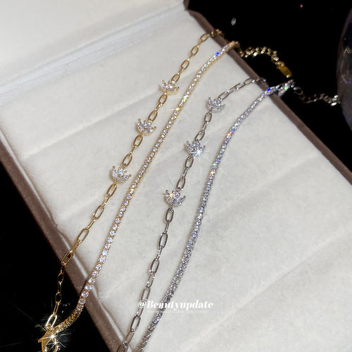 Gold and silver CZ tennis and paperclip flower bracelets in jewelry tray