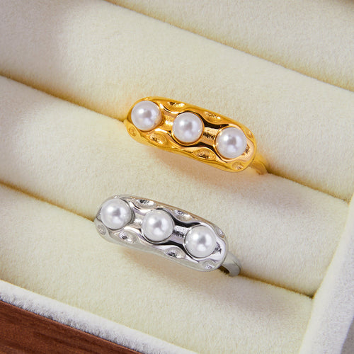 Gold and silver pearl rings displayed in cream jewelry tray