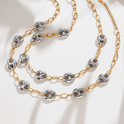 Two-tone hollow pig-nose bead necklace coiled on white