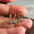 Gold Tone Huggie Earrings with Crystal Bow Drops with Clear Crystal Details view 1