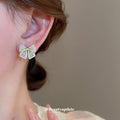 Gold Tone Crystal Bow Stud Earrings With Small Pearl Details view 3
