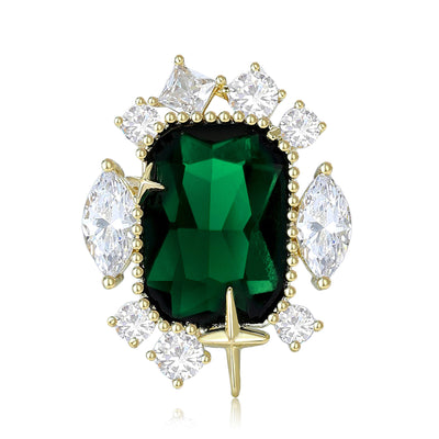 Emerald green oval gem brooch with clear stones on white background