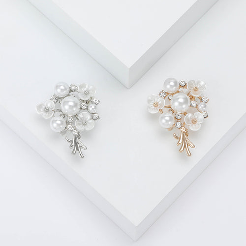 Silver and gold pearl bouquet flower brooches side by side on white