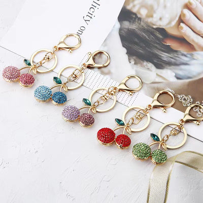 Five rhinestone cherry keychains in pink blue purple red and green