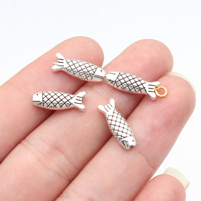 Fish shaped spacer bead arranged on a wood surface