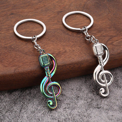 Silver and iridescent microphone treble clef keychains displayed side by side.
