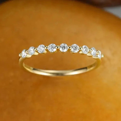 Gold tone bezel clear stone thin band ring on orange fabric