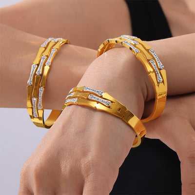 Gold geometric rhinestone link bangles stacked on both wrists
