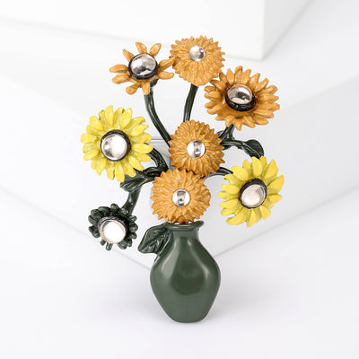 Front view of the sunflower bouquet vase brooch in yellow and green with polished metal detail on a white background