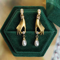 Gold Tone Hand Motif Drop Earrings Holding Pearl Drops view 2