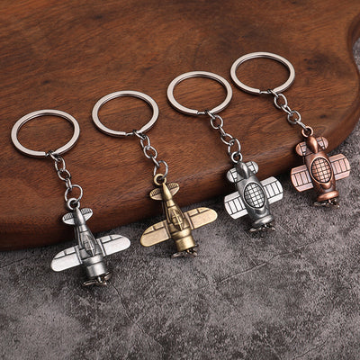 Four aircraft-shaped key rings display two charm designs in bronze, copper and silver tones.