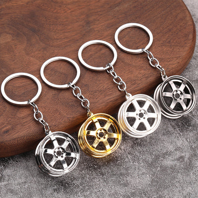 Four wheel rim keychains in silver, gold, matte silver, and gunmetal finishes.