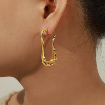 Gold goose neck open earring worn on ear side profile