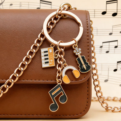 Front product photo of guitar piano violin and headphone charm keychain showing the pictured design arrangement