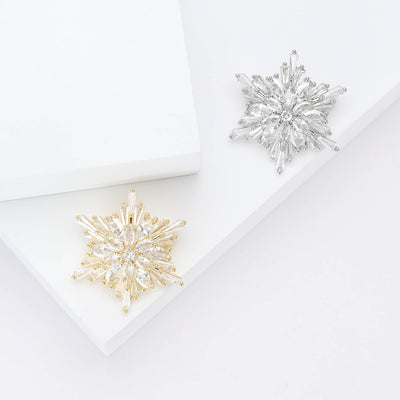 Gold and silver clear crystal snowflake brooches on white stepped display
