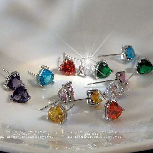 Assorted colorful heart crystal studs on white plate