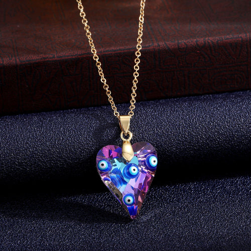 Four-eye iridescent purple heart pendant necklace on dark fabric