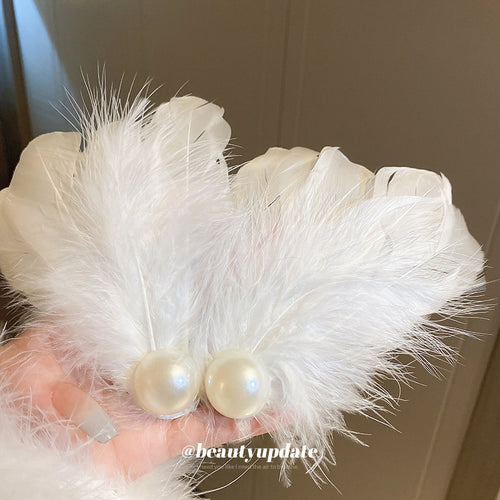 white feather hair clip with a large pearl-like center shown worn in a styled second view
