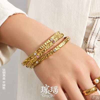 Model wrist stacked with hammered gold zirconia bangles