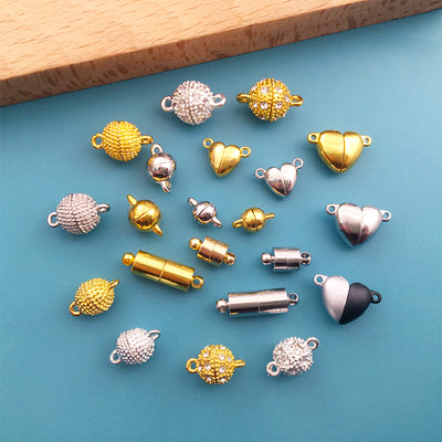Gold-tone connector clasp jewelry findings arranged on a light background