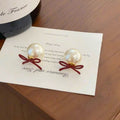 Red Bow Stud Earrings With White Pearl Drops and Gold Tone Edges view 2