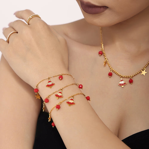 Close-up of gold bracelets with red enamel Christmas trees, stars and red beads, matching necklace