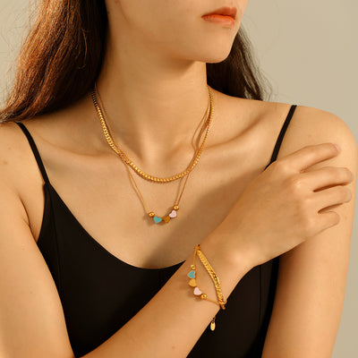 Model wears gold double-layer heart necklace and bracelet