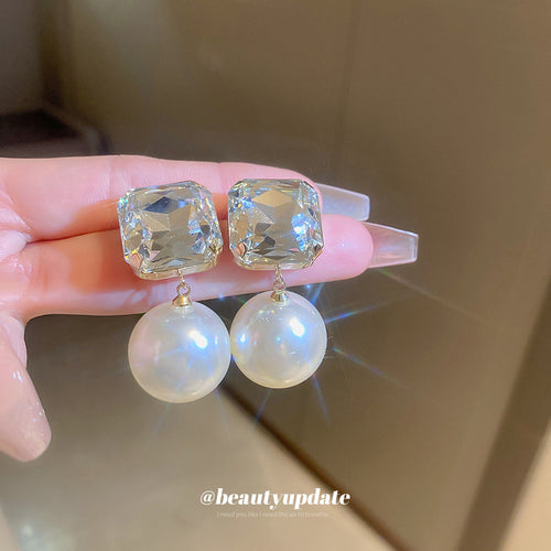 Square Crystal Pearl Drop Stud Earrings displayed on a tabletop