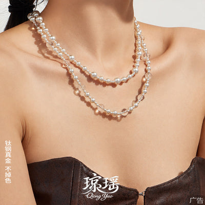 Layered pearl and clear bead necklaces on model collarbone