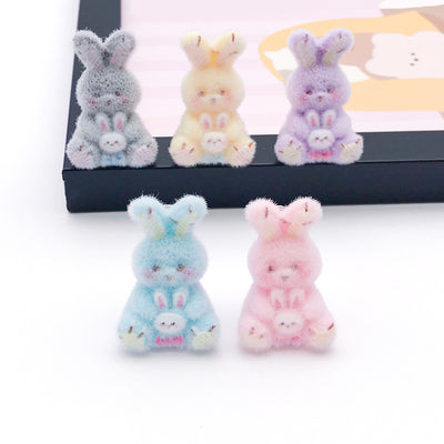 Multicolor rabbit charms arranged on a light background