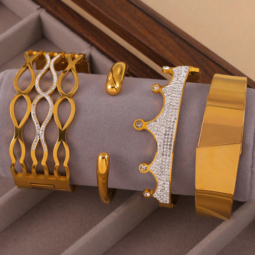 Four gold bangle styles displayed on gray jewelry roll
