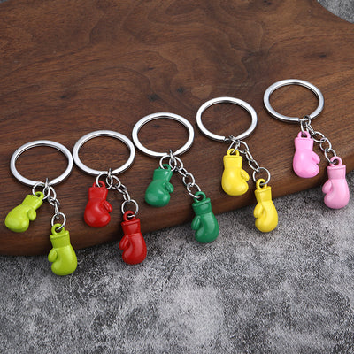 Five silver-tone split rings display paired glove charms in light green, red, green, yellow, and pink.