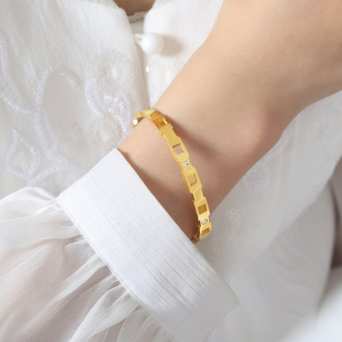 Side view of gold cutout zircon bangle on wrist