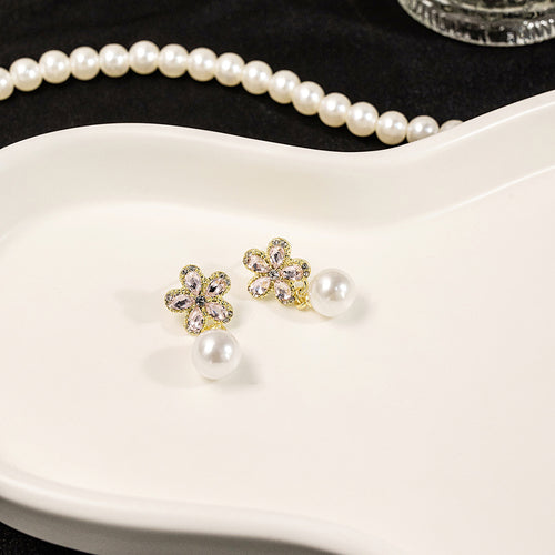 Pink flower pearl studs on white ceramic dish