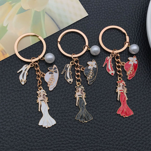 Alternate arrangement of the white black and red dress mannequin metal keychain showing its hardware and charm details